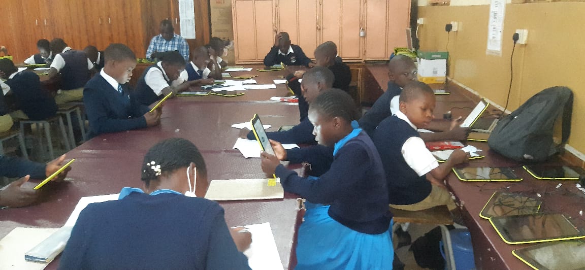 Students working collaboratively with digital devices and tablets