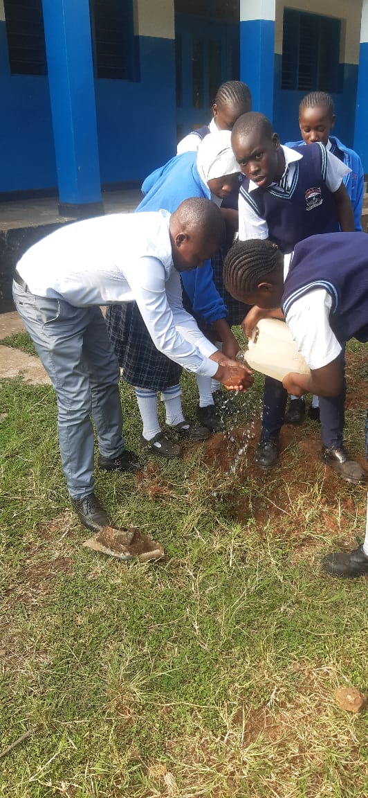 Students and teachers working together in tree planting ceremony